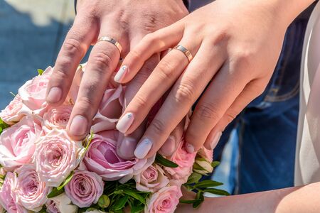 Wedding rings on the hands of newlyweds