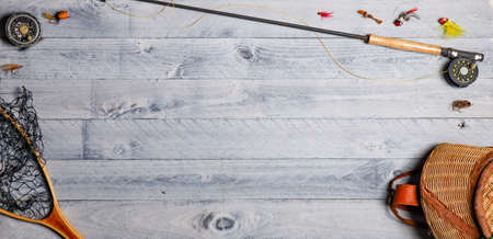 Fly fishing equipment overhead on wooden background with copy spaceの写真素材