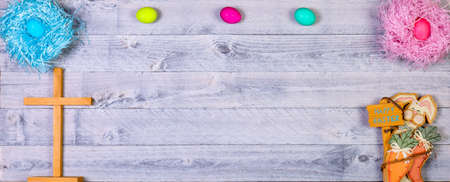 Easter cross, eggs, and bunny overhead on wooden background with copy space