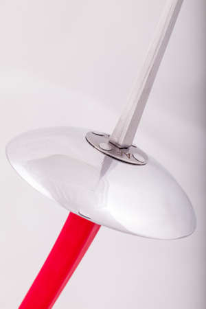closeup of a foil sword with a red handle