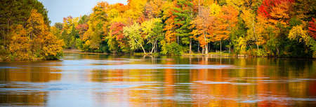 Colorful autumn trees reflecting off of the Wisconsin River in Merrill, Wisconsin, panoramaの写真素材