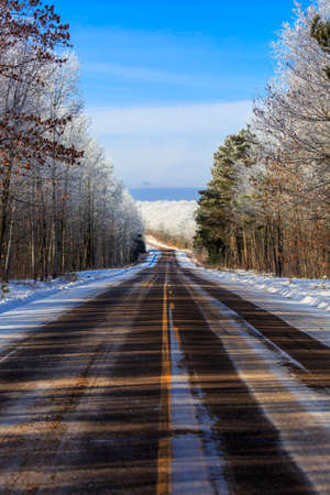 Highway E running through a frost covered forest in northern Wisconsin in January, verticalの写真素材