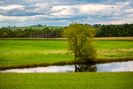 Wisconsin farmland and  pond with a dramatic sky in September, horizontal