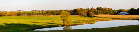 Wisconsin farmland with pond in late September, panoramaの写真素材