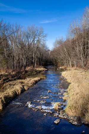 Eau Claire River in central Wisconsin starting to ice up on a calm November day, verticalの写真素材
