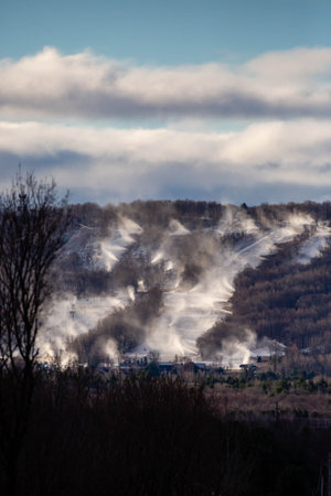 Snow cannons making snow on Granite Peak Ski Hill in Rib Mountain, Wausau, Wisconsin just before they open, verticalの写真素材