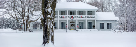 Gold and white front door decorated with Christmas decorations and snow, panoramaの写真素材