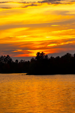 Colorful sunset on lake of the Falls in Mercer, Wisconsin, verticalの写真素材