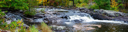Waterfalls flowing into Lake of the Falls in Mercer, Wisconsin in September, panoramaの写真素材