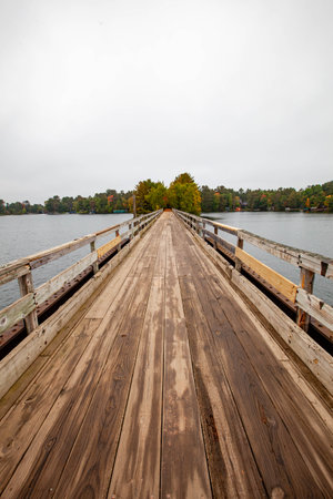 Bearskin Trailhead Bridge in Minocqua, Wisconsin over Lake Minocqua in September, verticalの写真素材