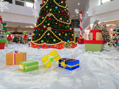 Christmas gift boxes on white canvas, decorated Christmas tree, colorful balloons, garlands, preholiday mood.の写真素材