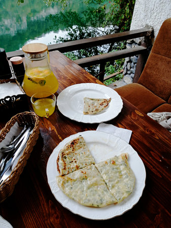Pancakes on a wooden table with a view of the lakeの写真素材