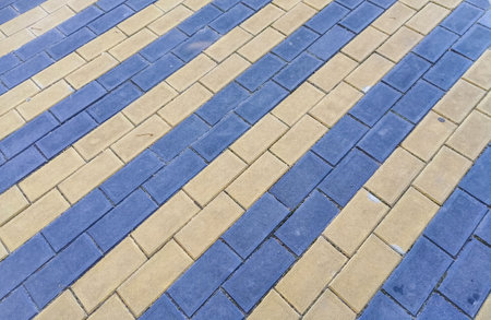 Background of paving slabs in brickwork diagonally in two colors, blue and light yellow.の写真素材