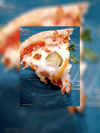 Piece of pizza with mozzarella cheese and cucumber on blue backgroundの写真素材