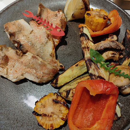 Grilled fish and vegetables on a plate. Toned.の写真素材