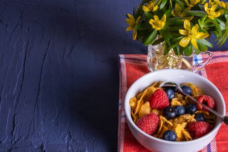berries, snowdrops and granola are on the table on a blue backgroundの写真素材