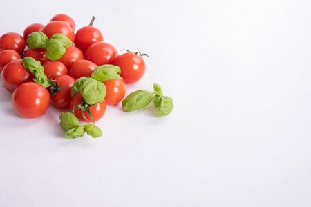 basil and fresh tomatoes on a table on a white backgroundの写真素材