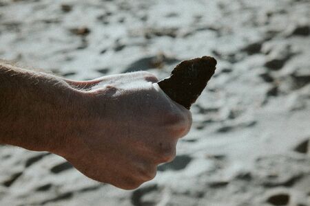 edged weapons of ancient people in the hand of a man on the seashore