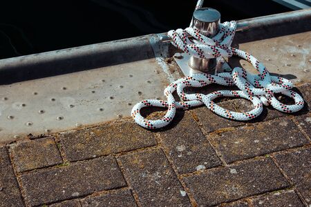 yacht mooring mount and rope tied to it, closeの写真素材