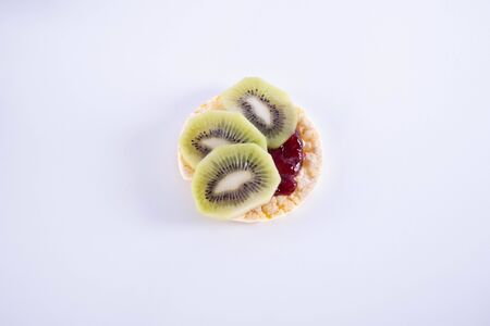 slices of kiwi and jam on a corn waffle on a white backgroundの写真素材