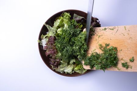 chopped salad and dill in a plate on a table on a white backgroundの写真素材