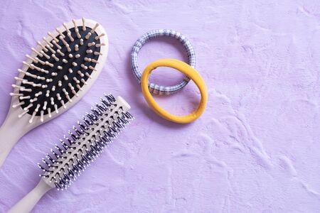 two combs and elastic bands for hair lie on a textured background and all on a white backgroundの写真素材