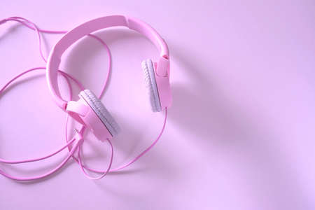 pink headphones and cable on a pink background near