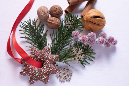 christmas decoration walnuts, spruce twig, christmas gingerbread with red ribbon on white background