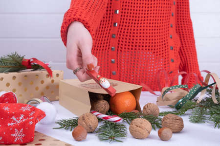 Christmas present, from a paper bag, from walnuts, tangerines and lollipops, sprinkled on the table