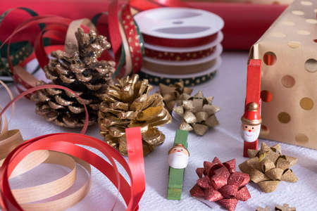 christmas decoration and wrapped gifts and clothespins santa claus, ribbons and fir cones, lie on a...