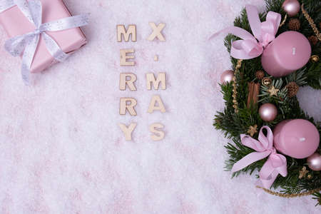 Christmas wreath, and "Merry Christmas" is written in the snow on a white backgroundの写真素材