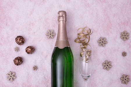 a bottle of champagne, a glass lie on a snow-covered table on a white backgroundの写真素材