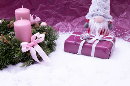 gift, gnome and festive wreath on pink backgroundの写真素材
