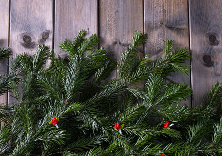 christmas fir branches on a wooden table on a brown backgroundの写真素材