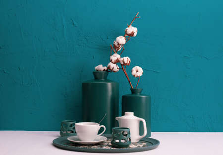 Breakfast with coffee on a tray, candlesticks, dry cotton plant in vases on a blue background on the tableの写真素材