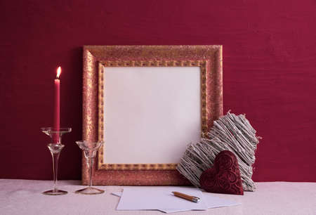 a candlestick on a long leg with a burning candle, two decorations in the shape of a heart, an old...