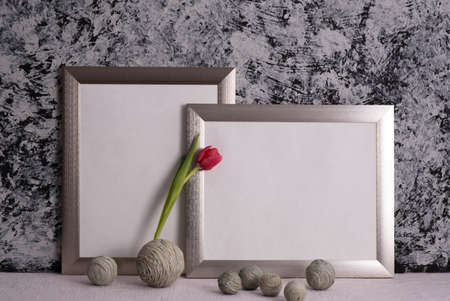 red tulip, gray photo frames and decor on a gray background on the tableの写真素材