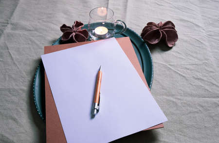writing utensils on the table, near a candle and decorations on a green backgroundの写真素材