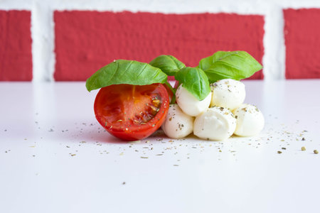 mozzarella with tomatoes and basil on a white table on a brick background
