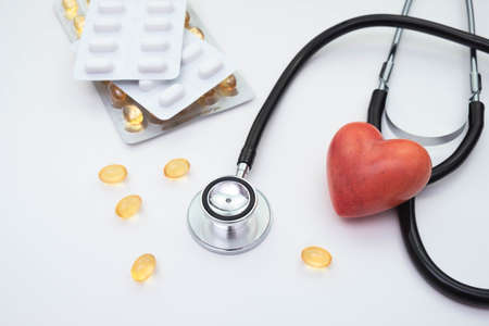 vitamins and pills, stethoscope and red artificial heart on a white background on the tableの写真素材