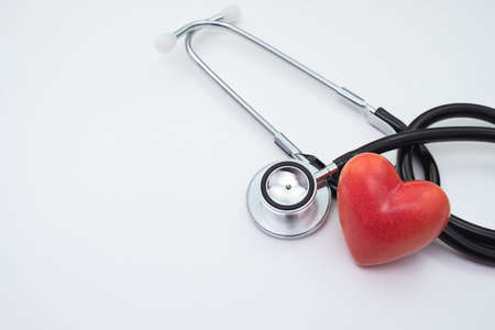 stethoscope and red artificial heart on a white background on the tableの写真素材