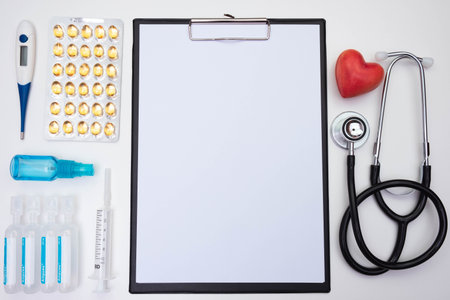 red heart made of stone, thermometer, antiseptic, water for injection, stethoscope, syringe on a white background on the tableの写真素材