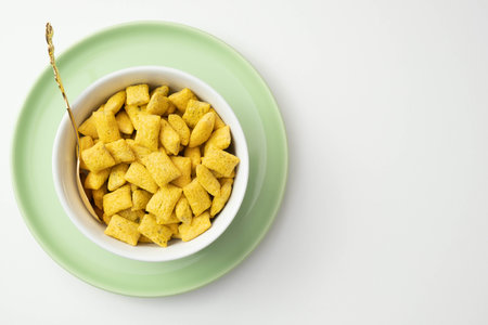 cornflakes and muesli in a green plate on a table on a white backgroundの写真素材