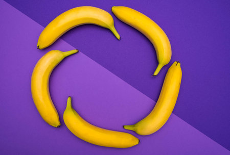 bananas laid out in a circle on a purple background, in the middleの写真素材