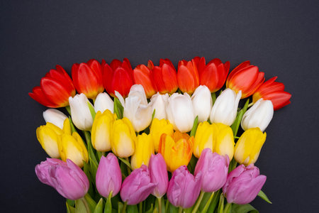 a large bouquet of colorful tulips on a black paper backgroundの写真素材