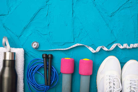 sport at home - white sneakers, dumbbells and jump rope, measurement tape, towel and water bottle,...