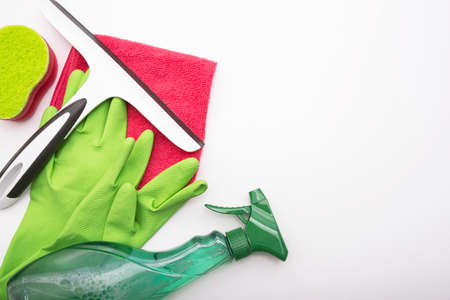gloves, cleaning products, rag and window cleaning brush lie on a white background, close-upの写真素材
