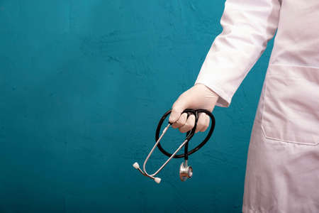 doctor and holding a stethoscope, on the left side of the textured, blue background