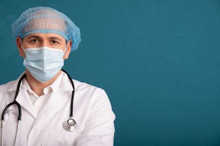 Nurse wearing hat and stethoscope on shoulders, close-up, blue backgroundの写真素材