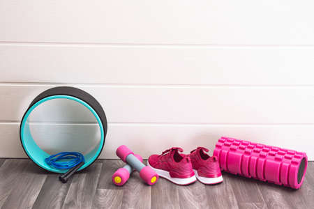 Sports equipment - pink sneakers, dumbbells, skipping rope and so far, at home, on a white background wallの写真素材